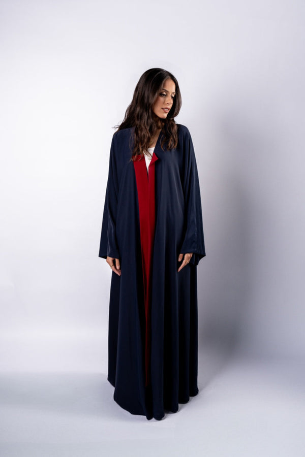 Woman wearing a long dark blue robe over a red outfit on a white background